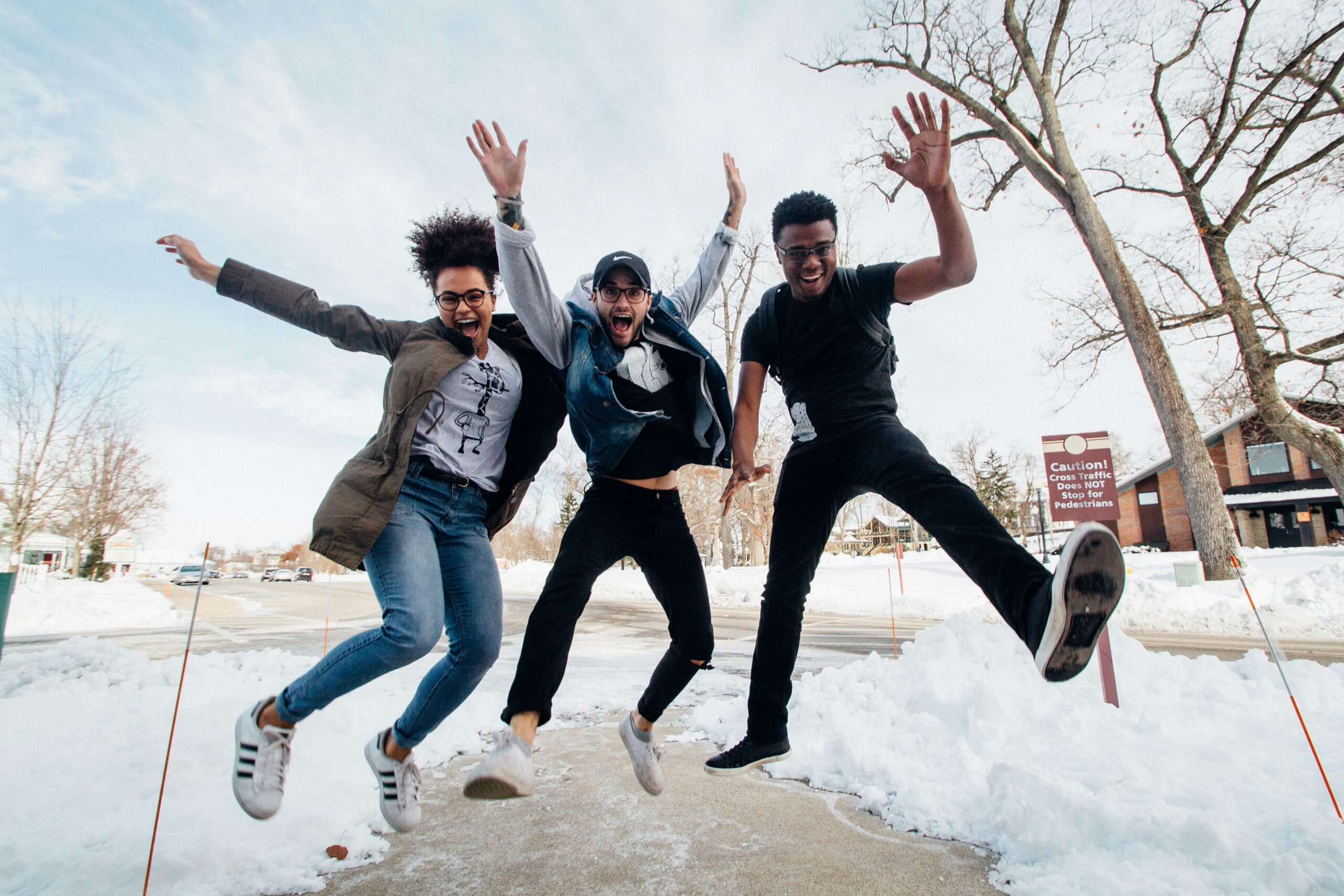 three teens jumping in the air and smiling